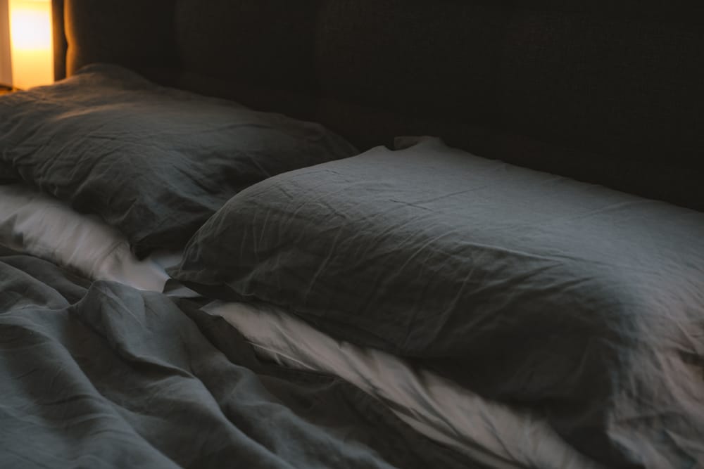 Unmade bed in a dark room